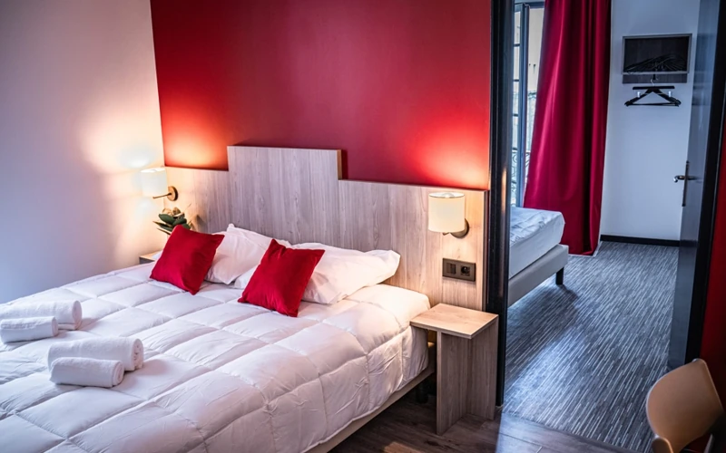 Chambre familiale Loge de la troupe avec lit double et mur rouge à l'Hôtel des Artistes à Chambéry