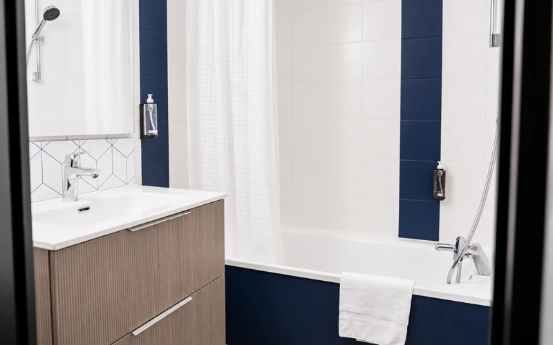 Salle de bain avec baignoire et lavabo de la Loge solo à l’Hôtel des Artistes à Chambéry