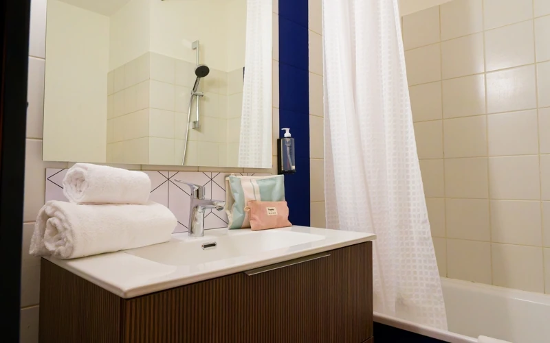 Salle de bain avec baignoire de la Loge solo à l’Hôtel des Artistes à Chambéry