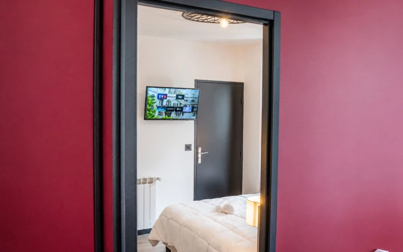 Aperçu de la chambre Loge de la troupe avec télévision murale et lit préparé à l'Hôtel des Artistes