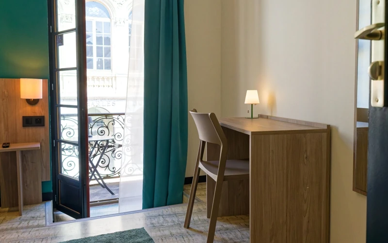 Coin bureau et balcon donnant sur l'extérieur dans la chambre Loge Duo de l'Hôtel des Artistes à Chambéry